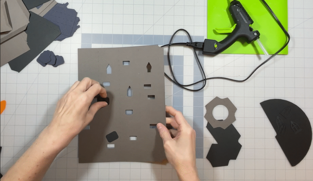 Flat 3D paper tower pieces arranged on a craft mat before assembly.