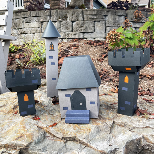 3D paper castle scene with gray towers and a main house, handmade from layered cardstock designed by Michelle Ward Designs.
