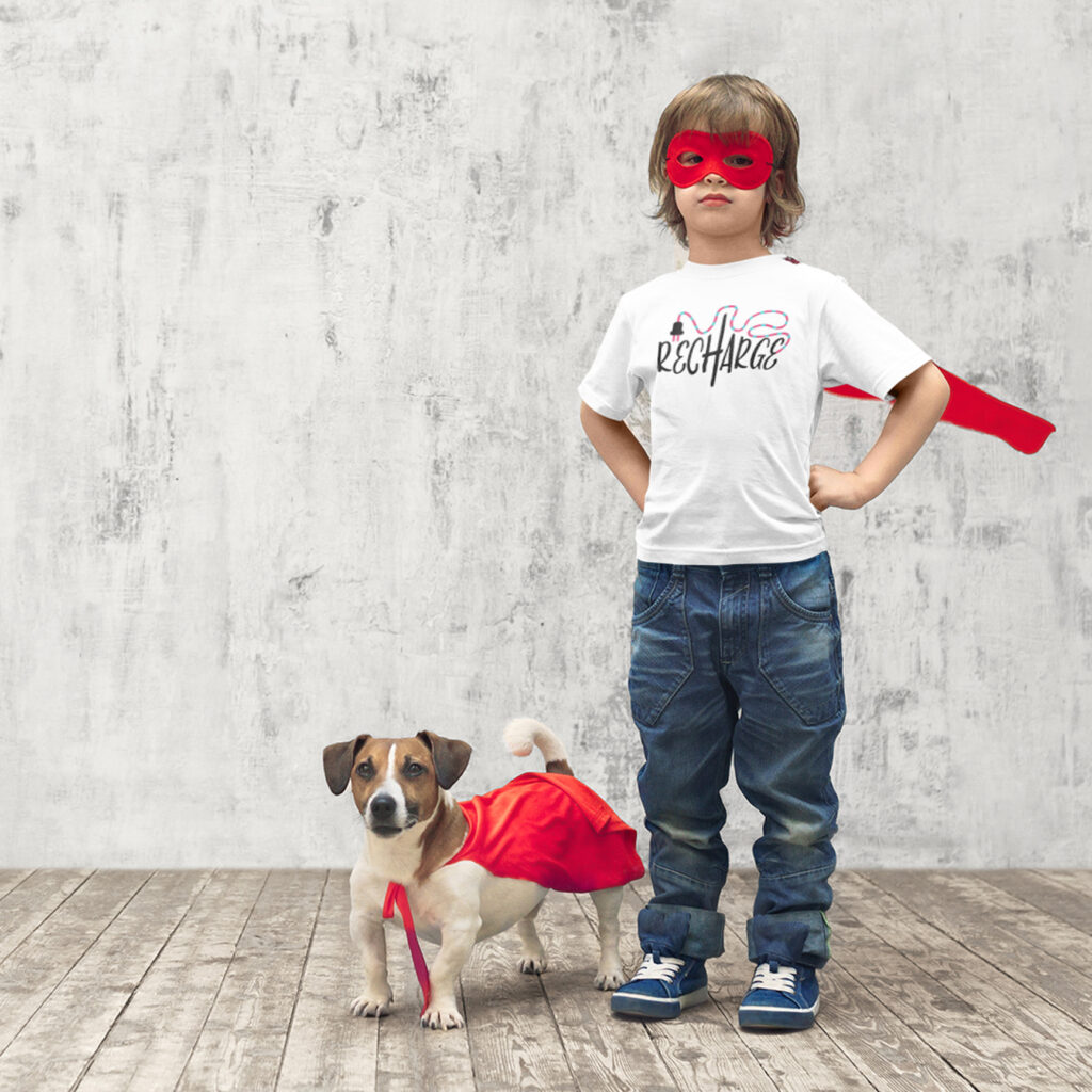 Child in superhero mask and cape wearing a t-shirt with the Recharge SVG design
