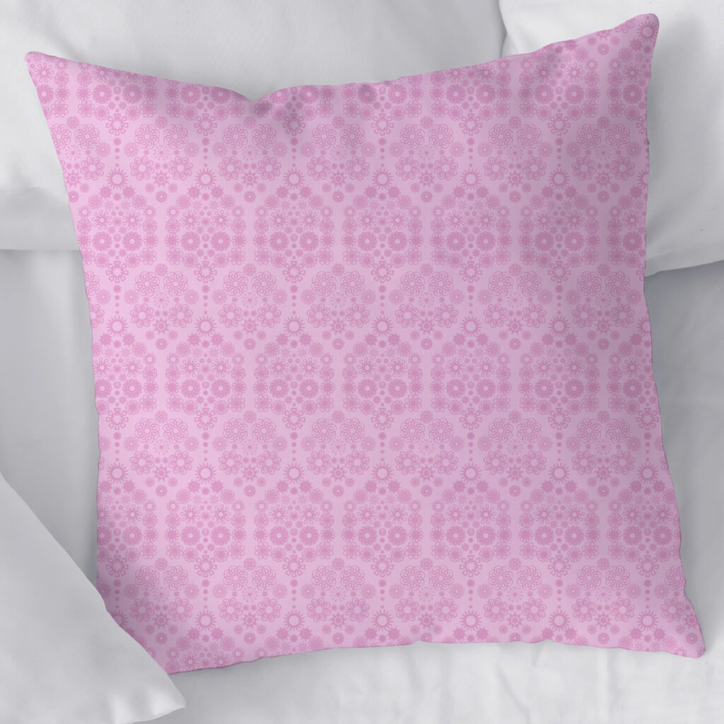 Square throw pillow printed with the pink damask repeating pattern from the Waddle and Whirl collection resting on bedding