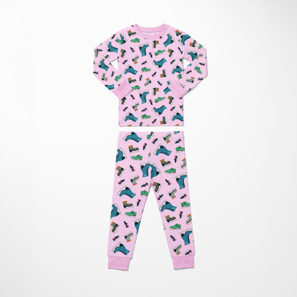Set of toddler pajamas printed with the pink repeating ice skate pattern from the Waddle and Whirl collection on a white background