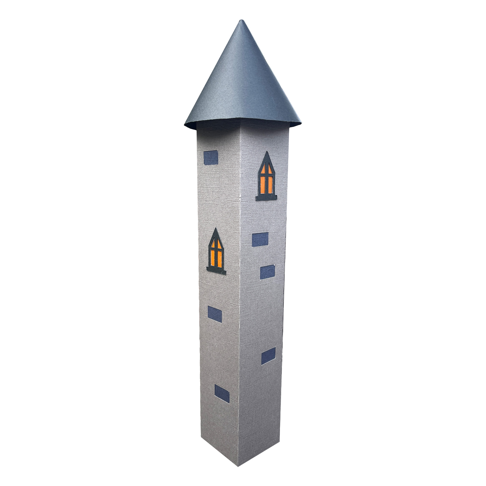 The finished Frankenstein Castle Tower: a tall, narrow gray paper tower with a pointed blue-gray cone roof and small windows glowing warm orange down its front.